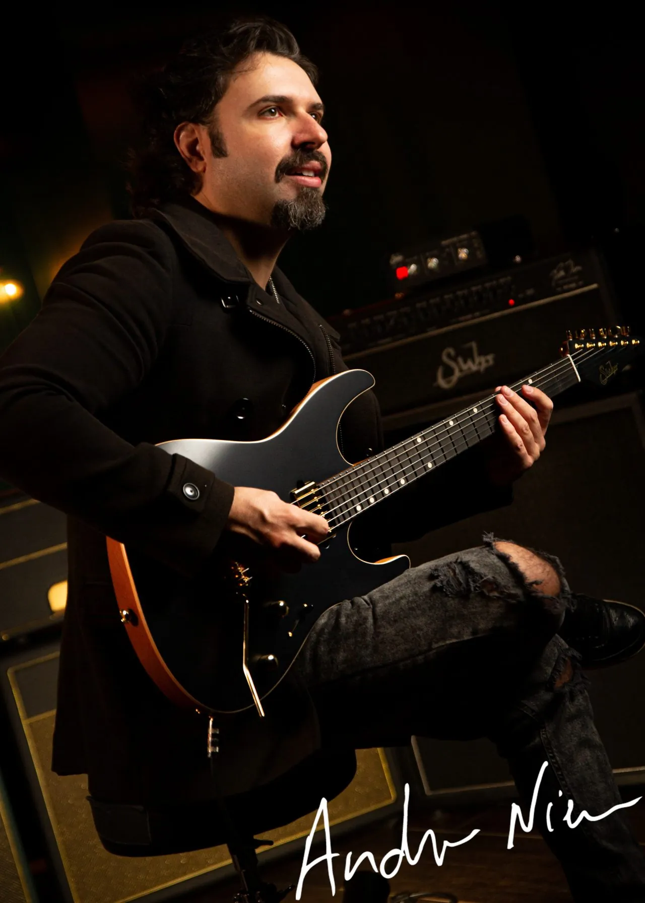 Andre Nieri com sua guitarra em frente a amplificadores